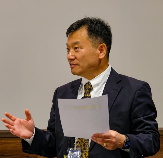 A man in suit and tie holding papers