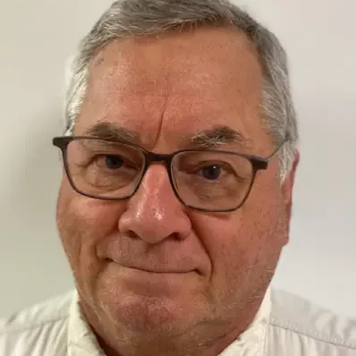 A man with glasses and a gray beard.